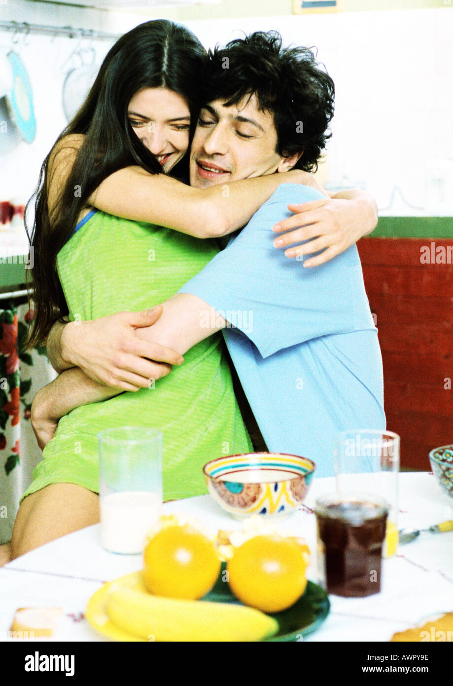 Couple hugging in front of table de petit déjeuner, portrait. Banque D'Images