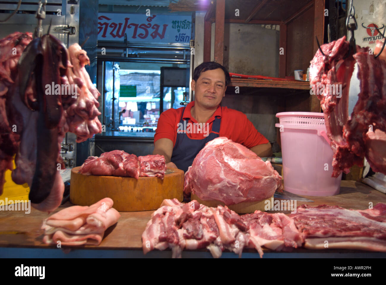 Marché de l'homme derrière le négociant viande étant offerts à partir de son échoppe à phetchabun, Thaïlande Banque D'Images