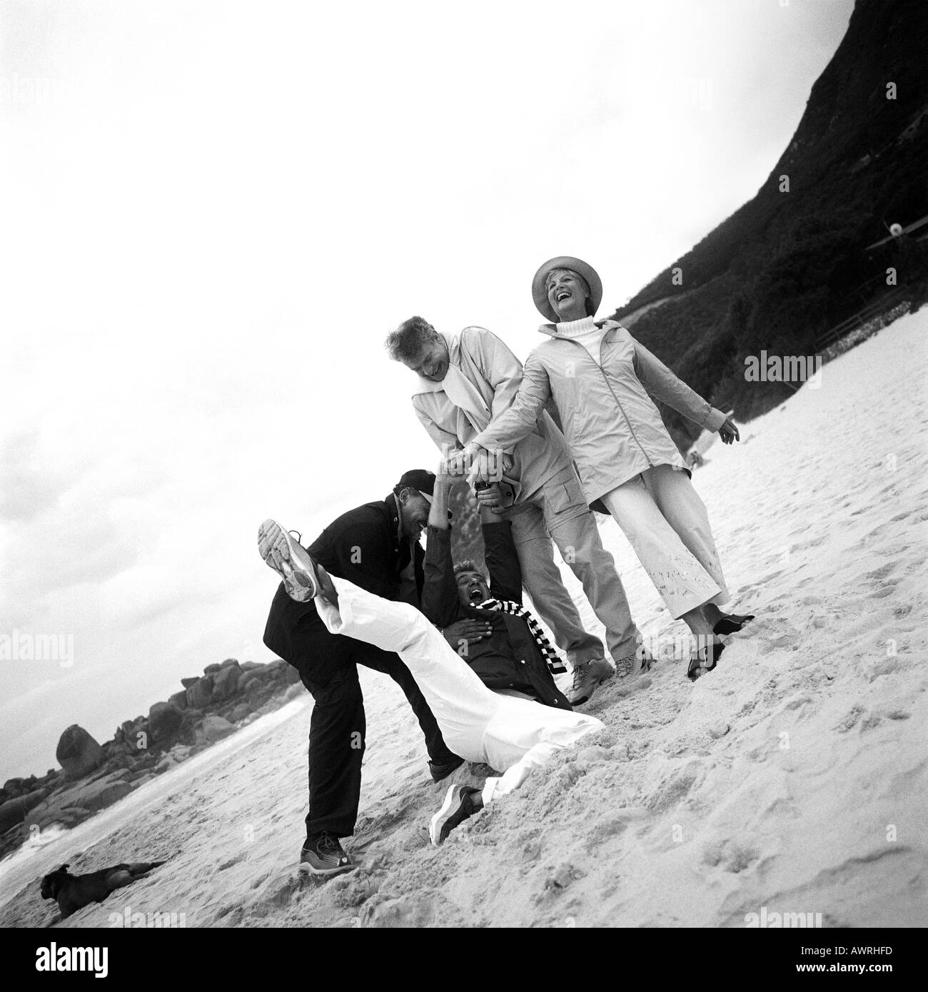 Groupe mature jouant sur plage, le b&w Banque D'Images