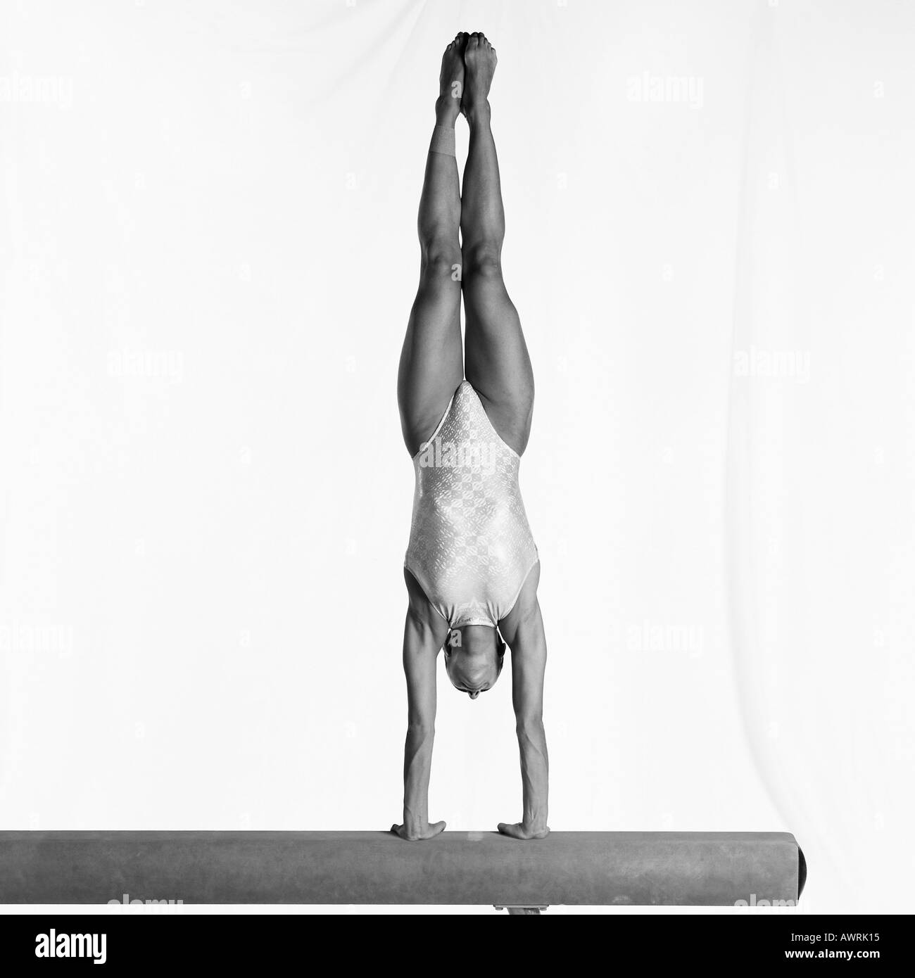 Jeune femme gymnast performing handstand sur poutre Banque D'Images