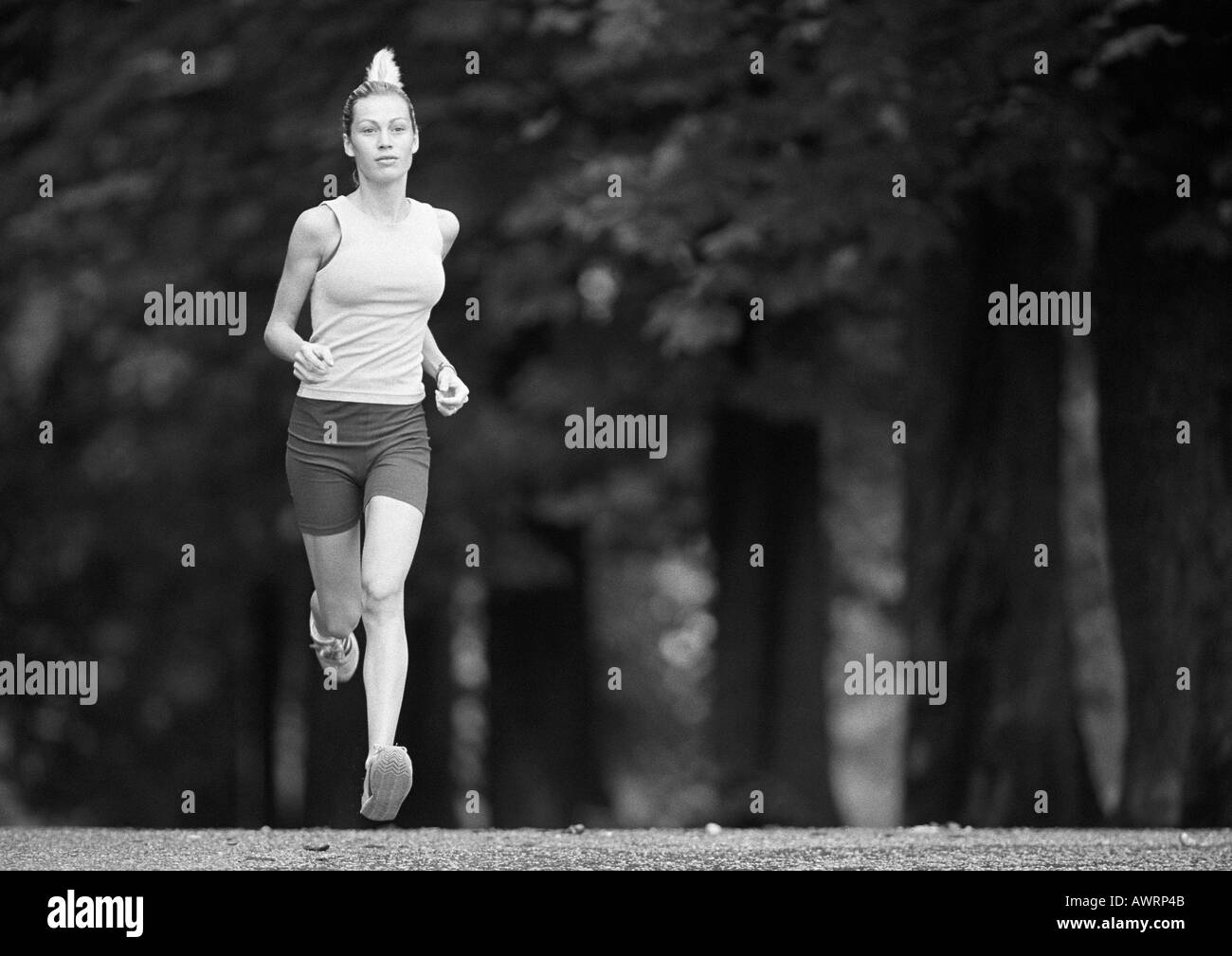 Femme en marche, arbres en arrière-plan, b&w Banque D'Images