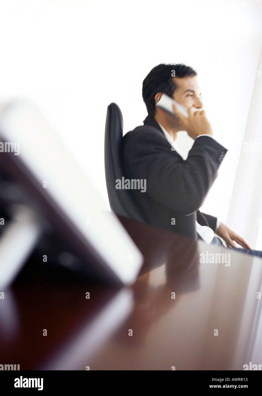 Businessman using phone, side view Banque D'Images