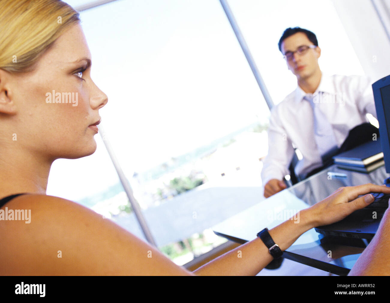 Businesswoman sitting at desk with businessman, portrait, close-up Banque D'Images