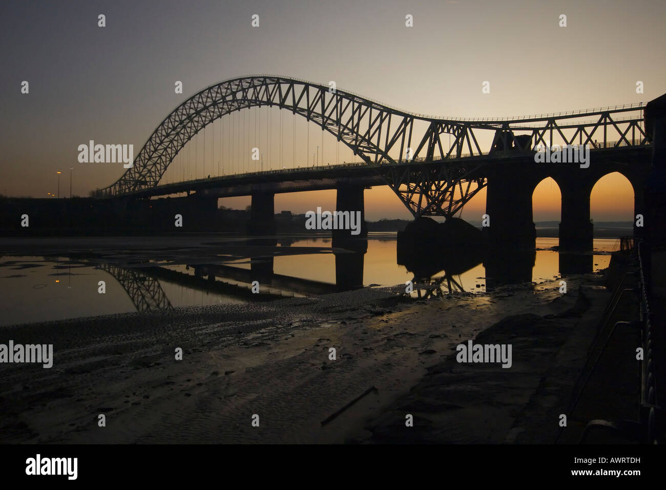 L'Runcorn Bridge traversant la rivière Mersey au coucher du soleil. Banque D'Images