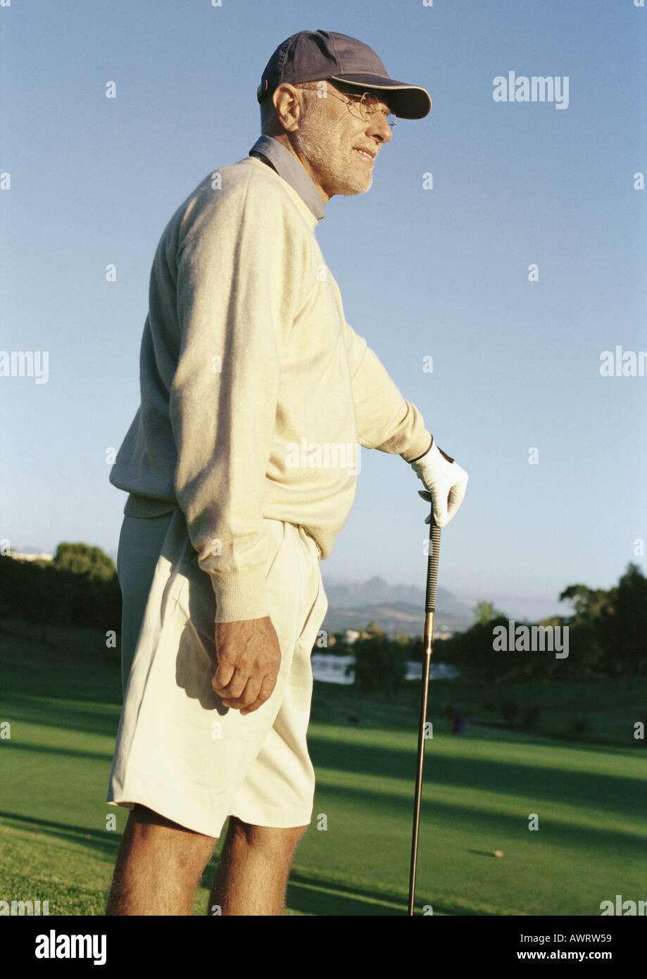 Young man leaning on golf club Banque D'Images