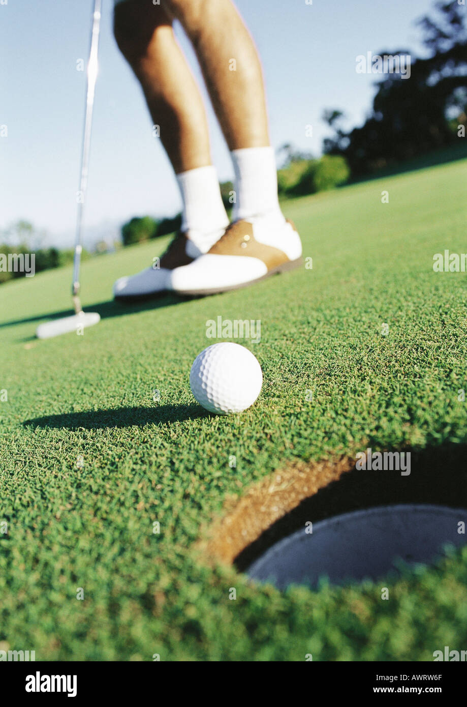 Balle de golf golfeur et près du trou, low section Banque D'Images