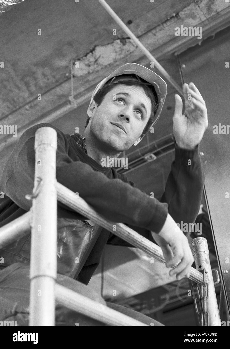 Travailleur de la construction sur des échafaudages, low angle view, waist up Banque D'Images