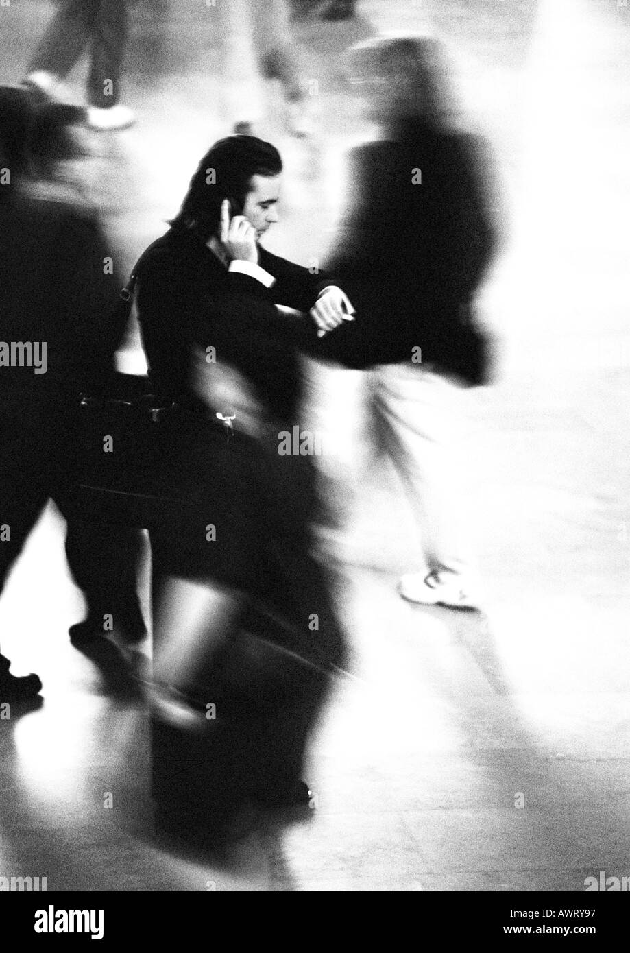 Portrait et en utilisant un téléphone cellulaire en foule, blurred motion, b&w Banque D'Images Portrait et en utilisant un téléphone cellulaire en foule, blurred motion, b&w Banque D'Images
