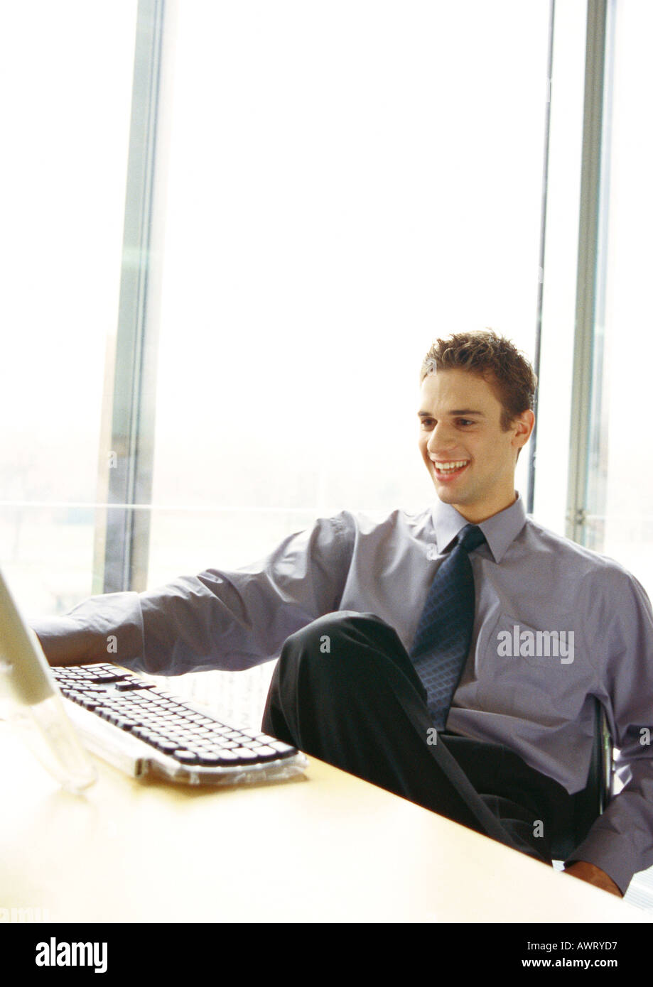 Businessman sitting at desk smiling Banque D'Images