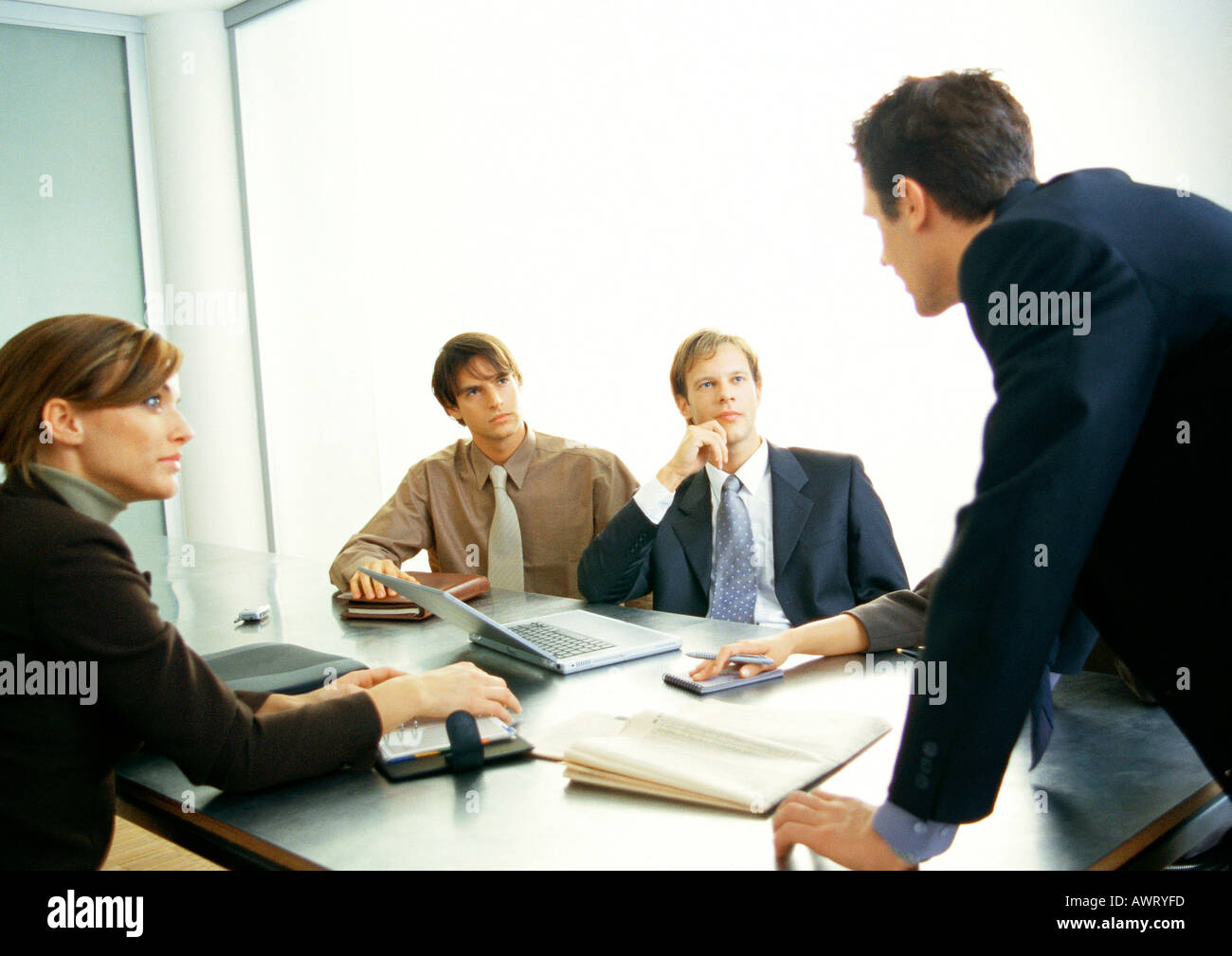 Business people looking at businessman standing Banque D'Images