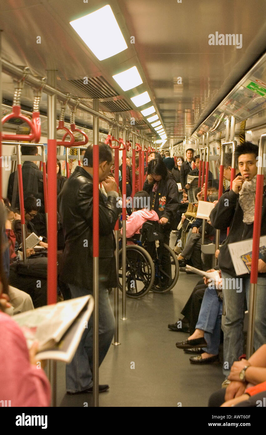 dh Mass Transit Railway MTR HONG KONG passagers debout la femme en train et le fauteuil roulant en chine les navetteurs du métro sont bondés Banque D'Images