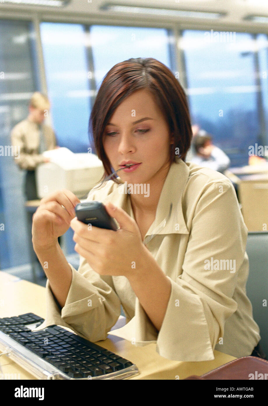 Numéros de frappe Businesswoman on cell phone in office. Banque D'Images