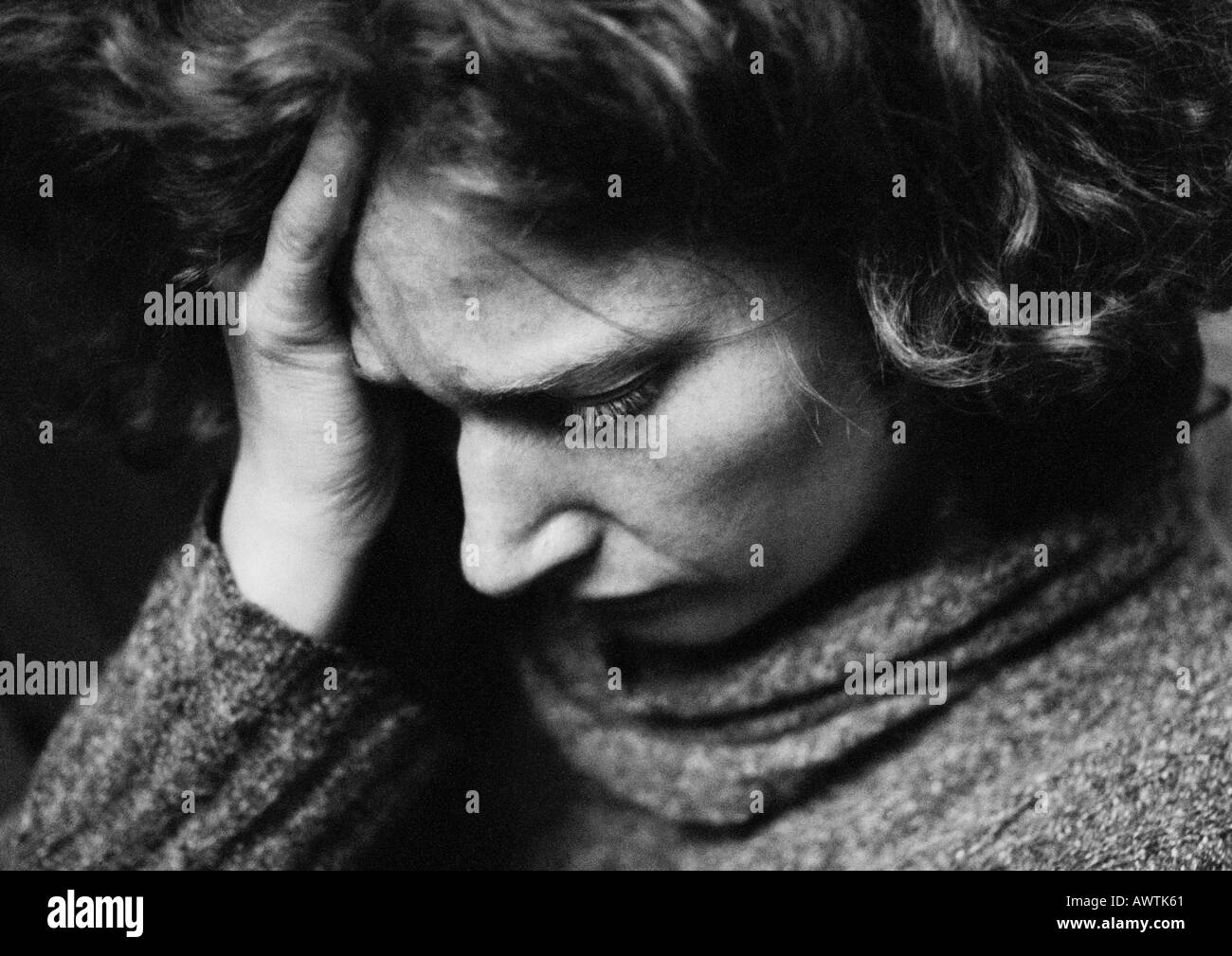 Woman holding head, close-up, b&w Banque D'Images