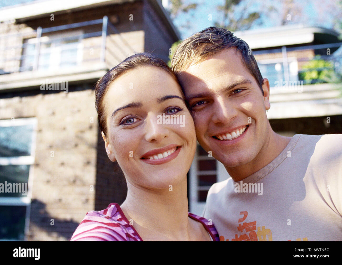 Couple in front of house, smiling, portrait Banque D'Images