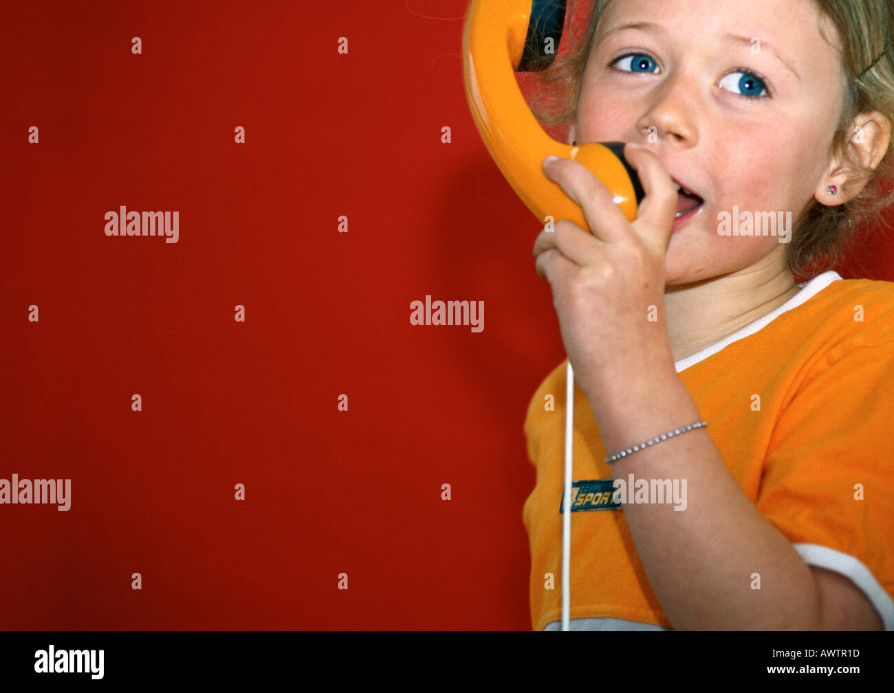 Petite fille parlant dans un téléphone jouet Banque D'Images