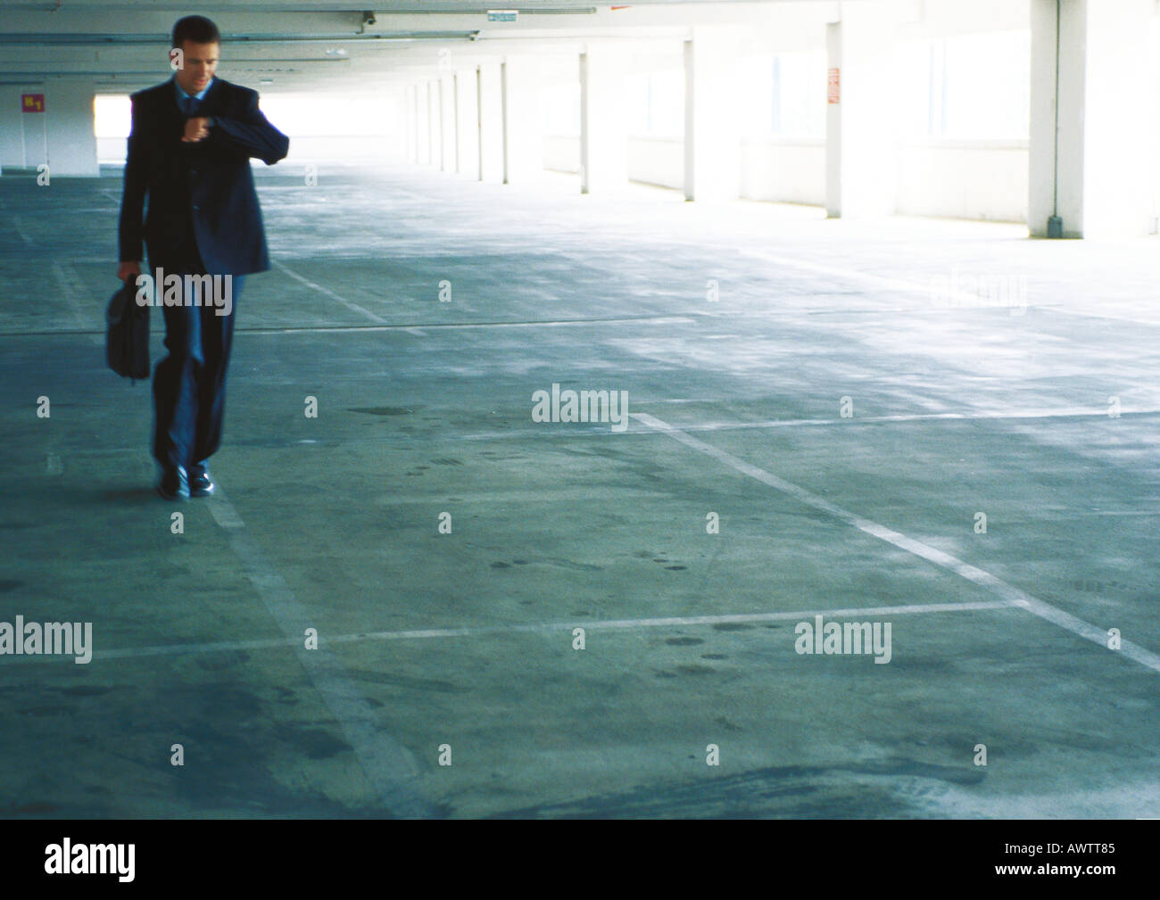Businessman walking dans un garage de stationnement, contrôle du temps Banque D'Images