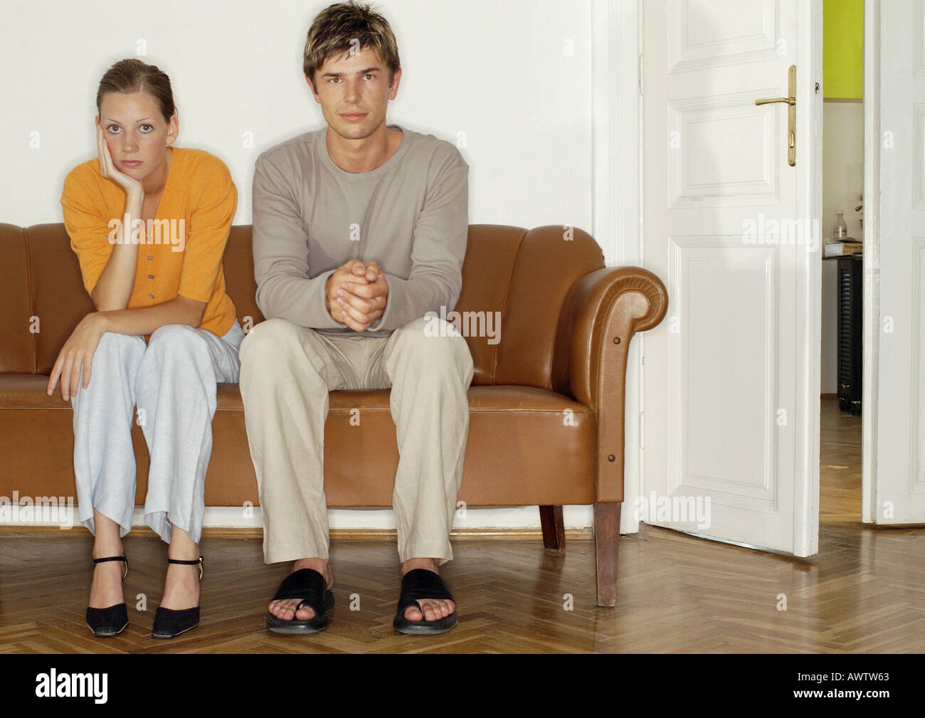 L'homme et la femme assis côte à côte sur le canapé Banque D'Images