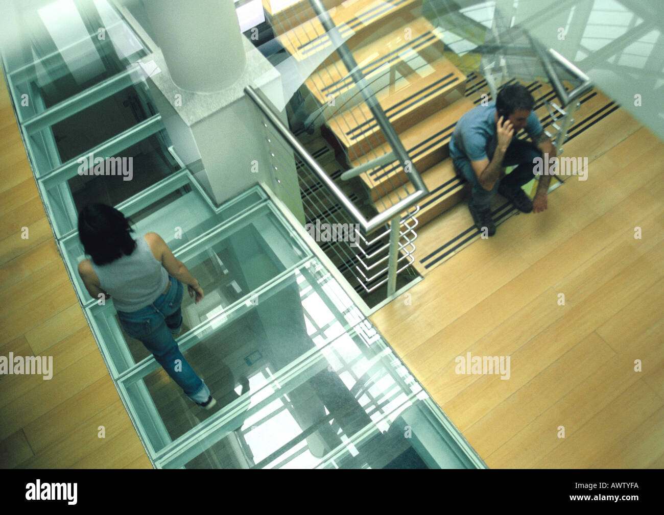 Femme marche passé man sitting on stairs on cell phone, vue d'en haut Banque D'Images