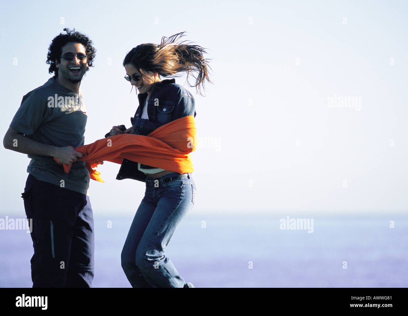 Man, l'empêchant de adolescente avec tissu orange Banque D'Images