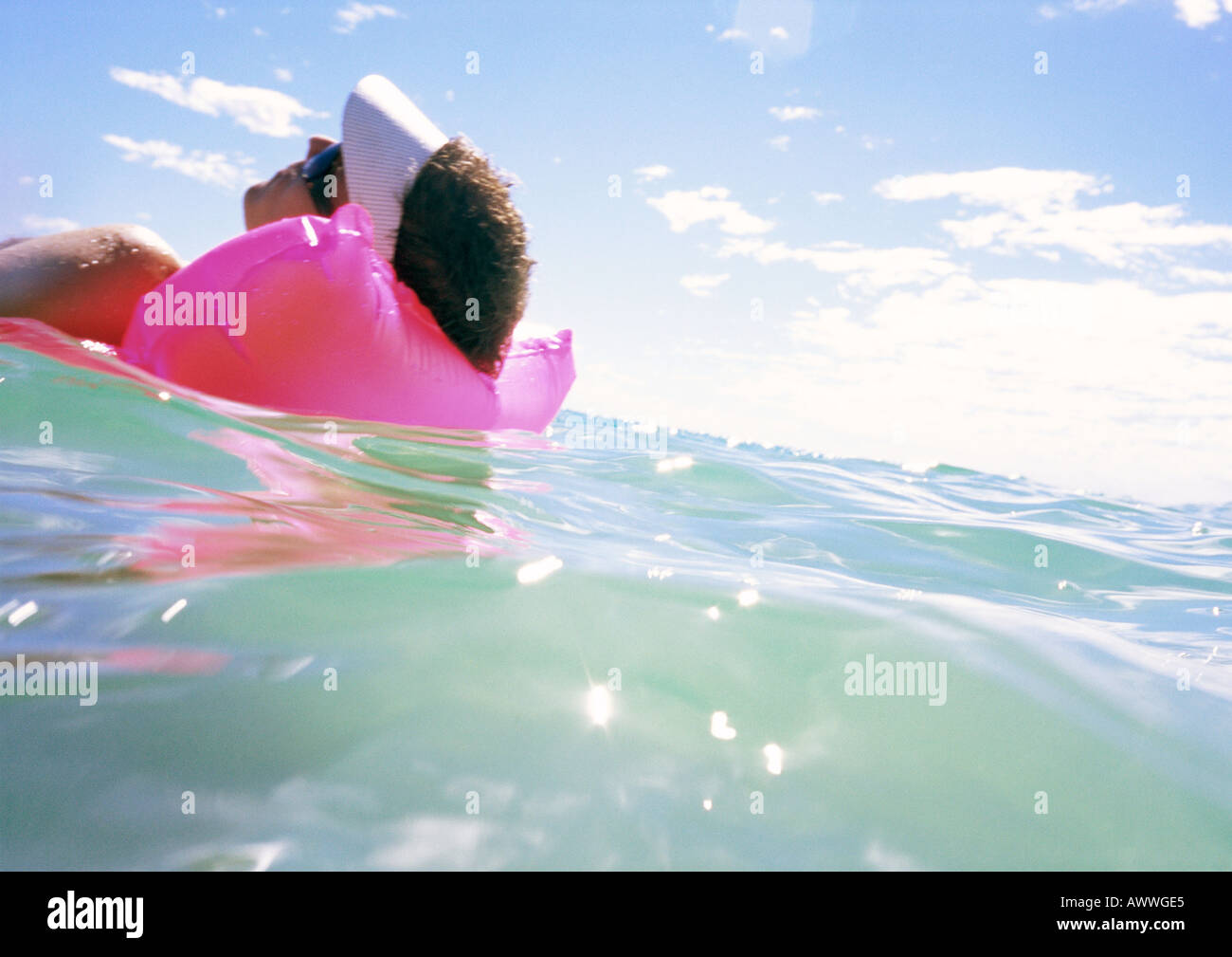 Homme flottant sur matelas d'air en mer, close-up Banque D'Images