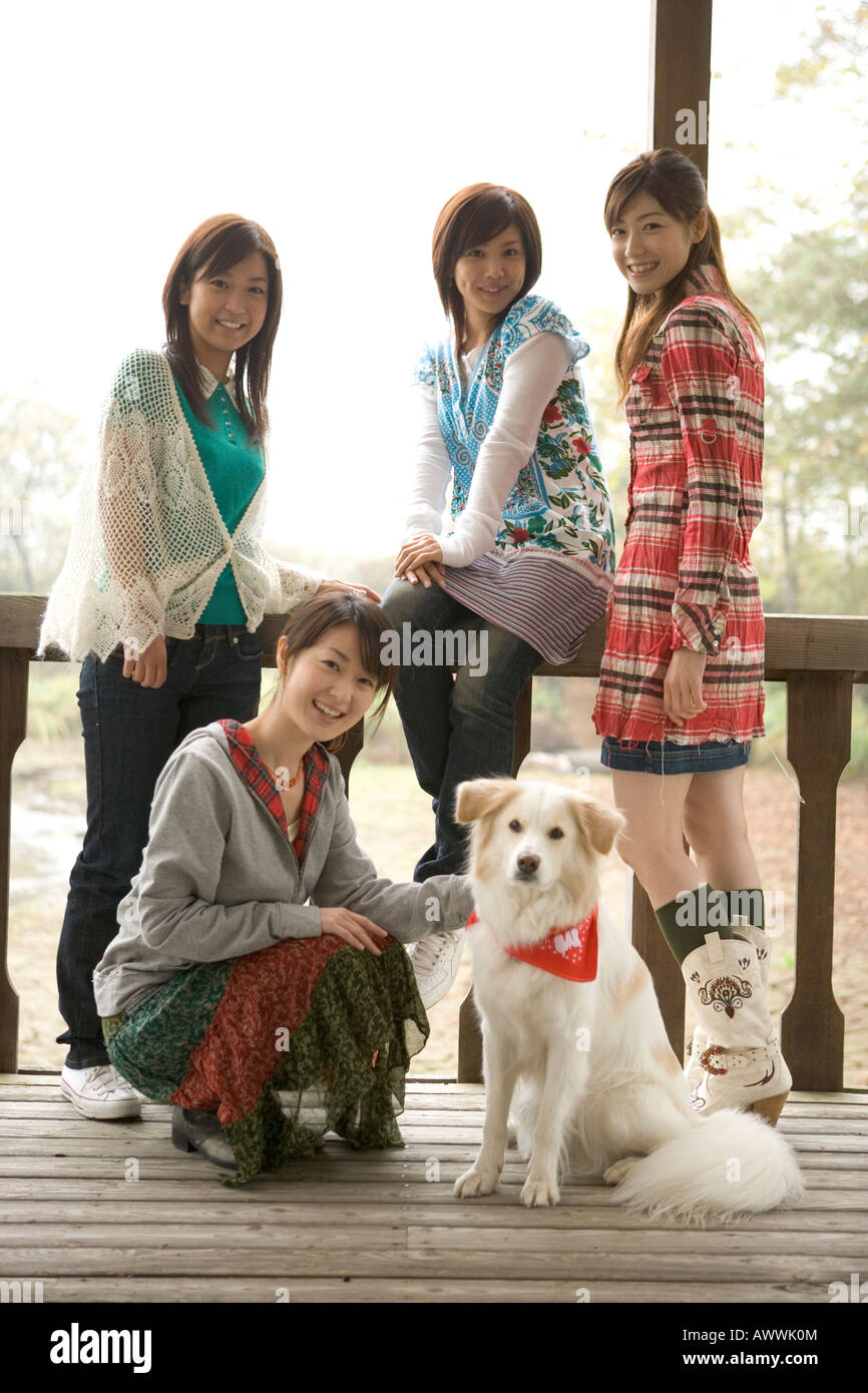 Portrait de quatre jeunes femmes avec chien sur porche Banque D'Images