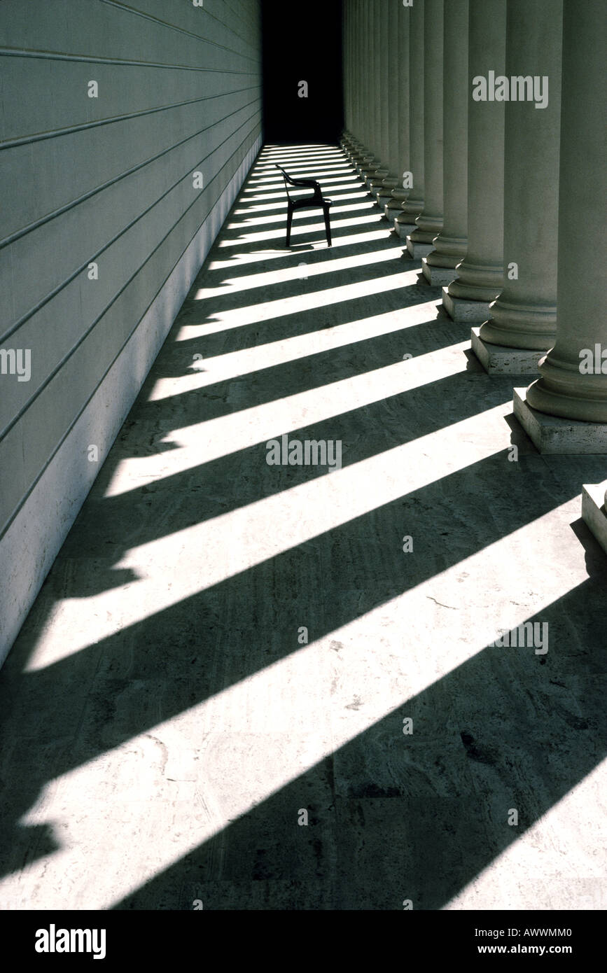 Un résumé photo d'une chaise dans l'ombre des colonnes romaines Banque D'Images