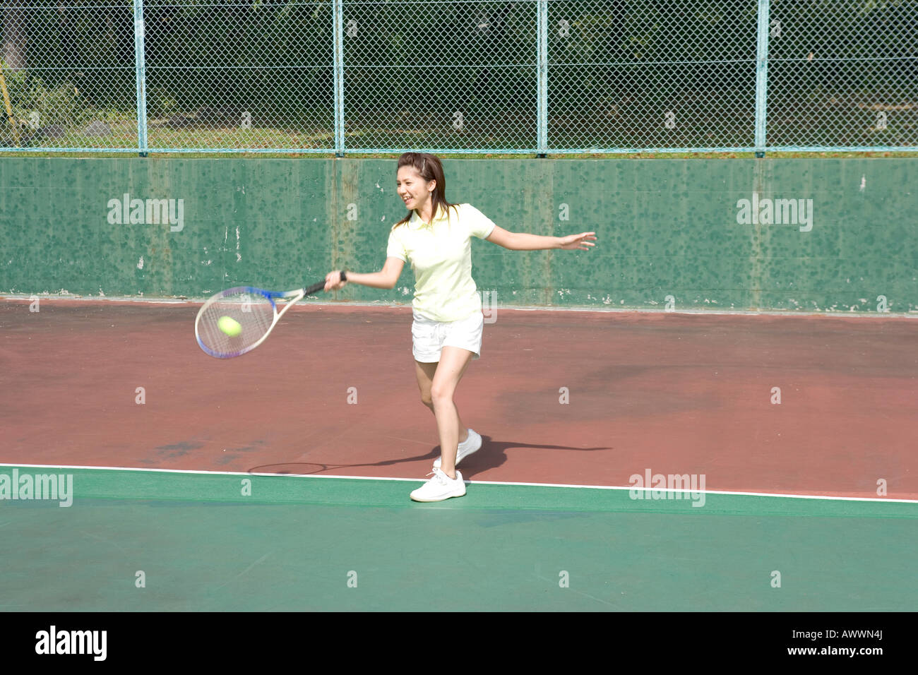 Teenage girl playing tennis sur cour Banque D'Images