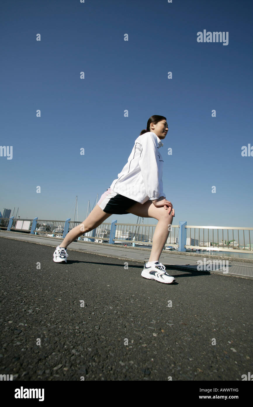 Young woman exercising on road Banque D'Images