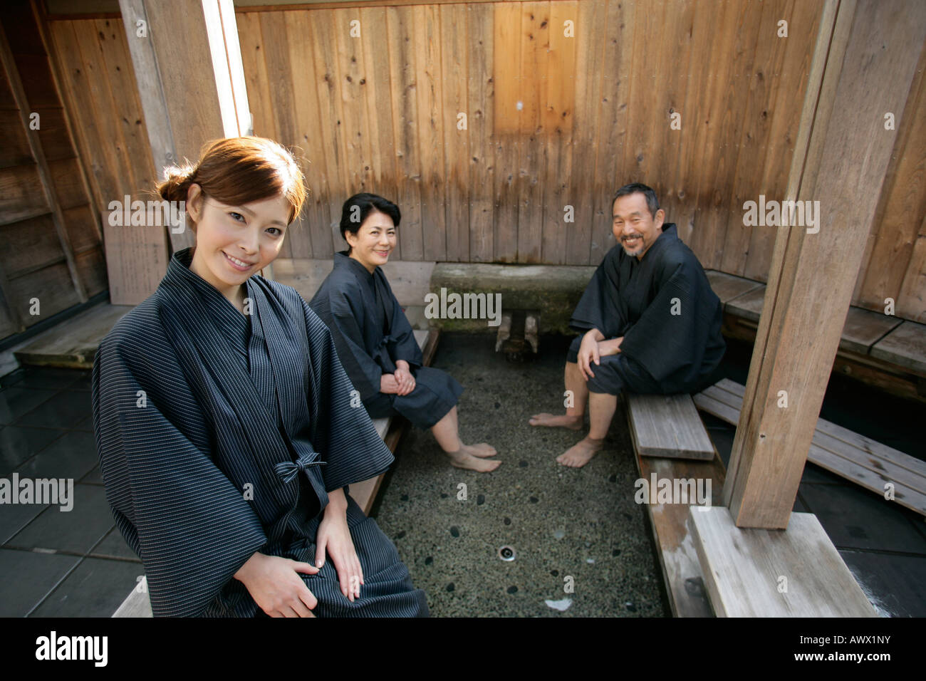 Couple de personnes âgées et jeune femme assise dans un spa japonais Banque D'Images