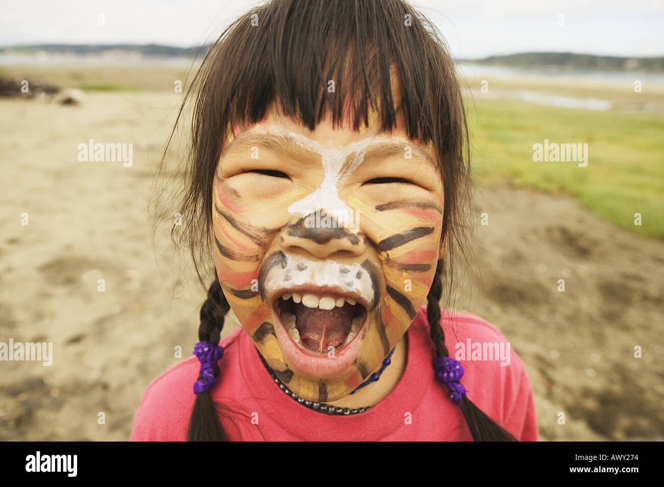 Fille avec visage peint comme un tigre rugissant Banque D'Images