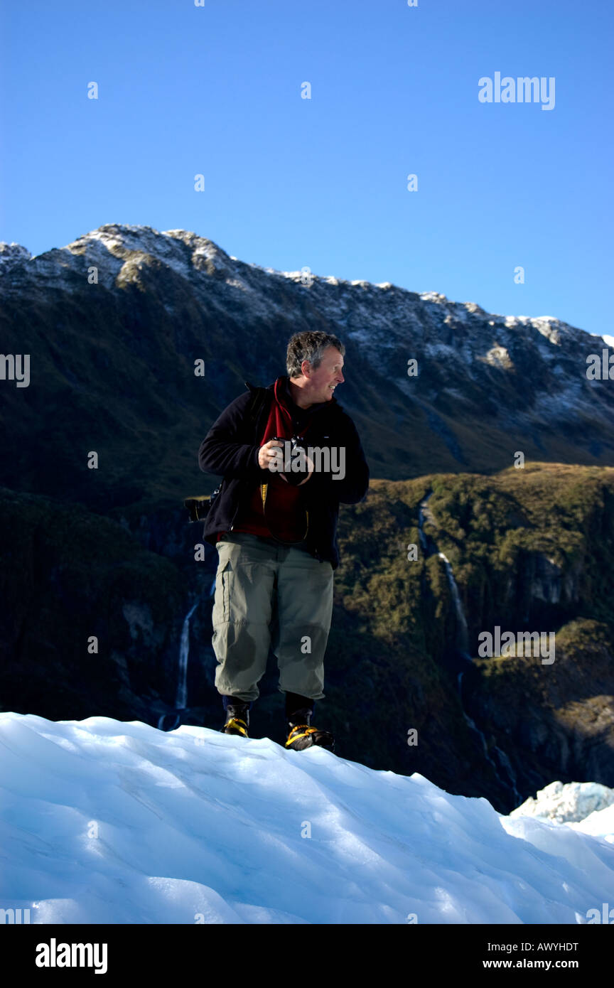 Terry Whittaker debout sur le Fox Glacier, New Zealand. Banque D'Images