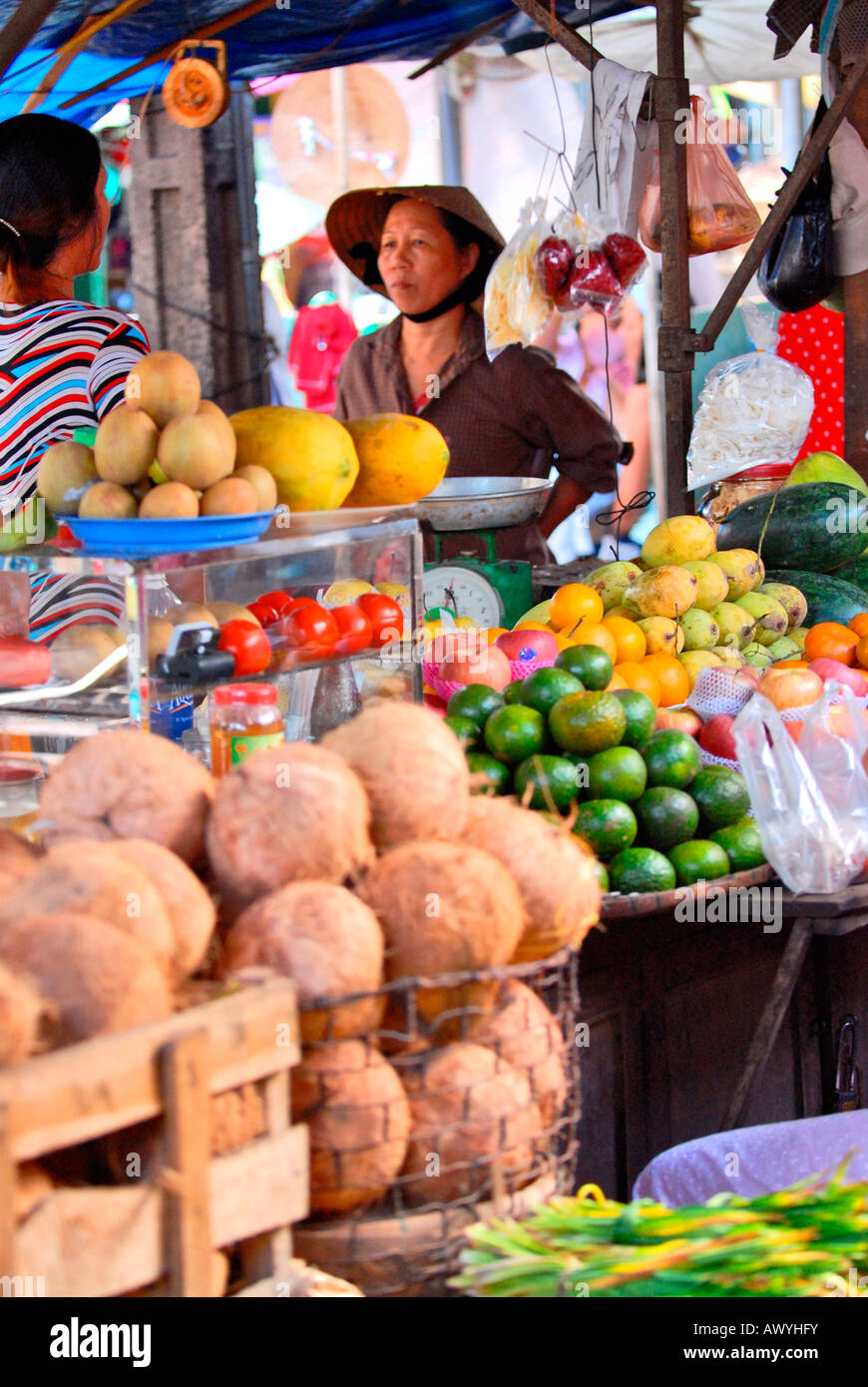 Asie extrême-Orient Vietnam , marché Hoi an , dame non bai tho , chapeau conique , et robe traditionnelle vendant des fruits et légumes frais Banque D'Images
