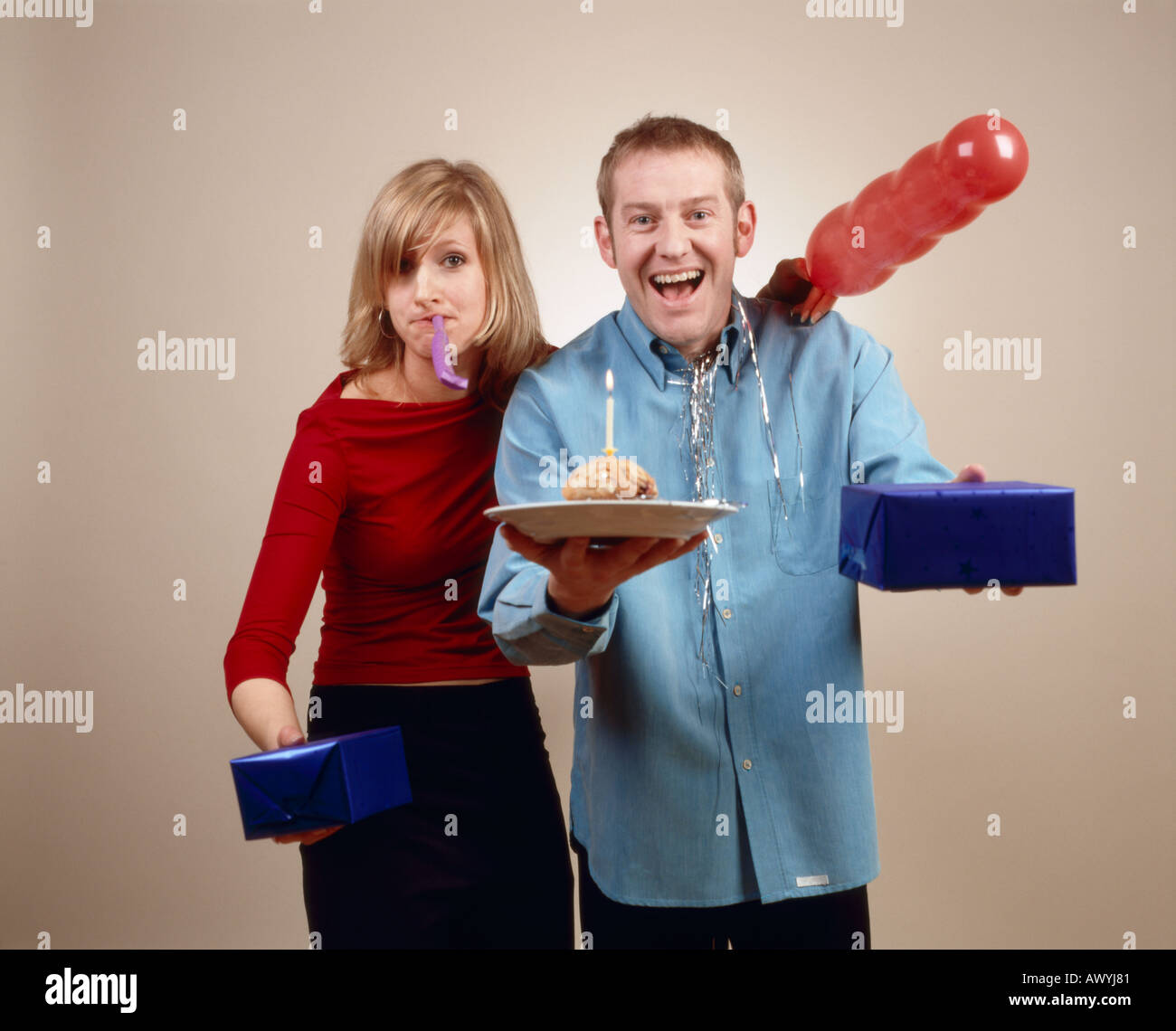 Couple avec gâteau d'anniversaire, ballon, sparkler et présente Banque D'Images