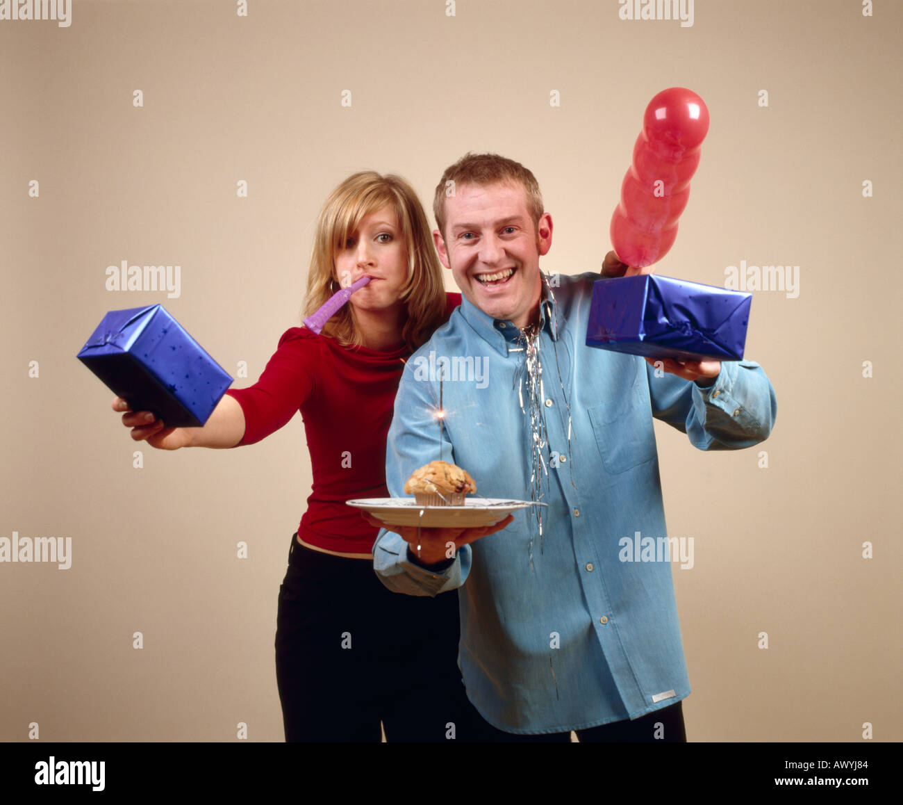 Couple avec gâteau d'anniversaire, ballon, sparkler et présente Banque D'Images