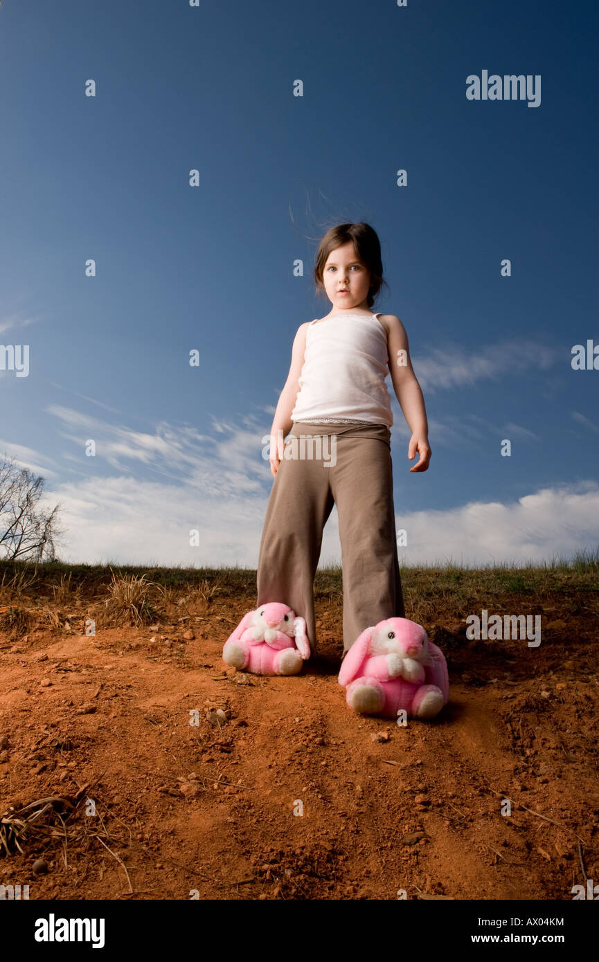 Une jeune fille portant des chaussons lapin joue sur une colline devant un  ciel bleu Photo Stock - Alamy