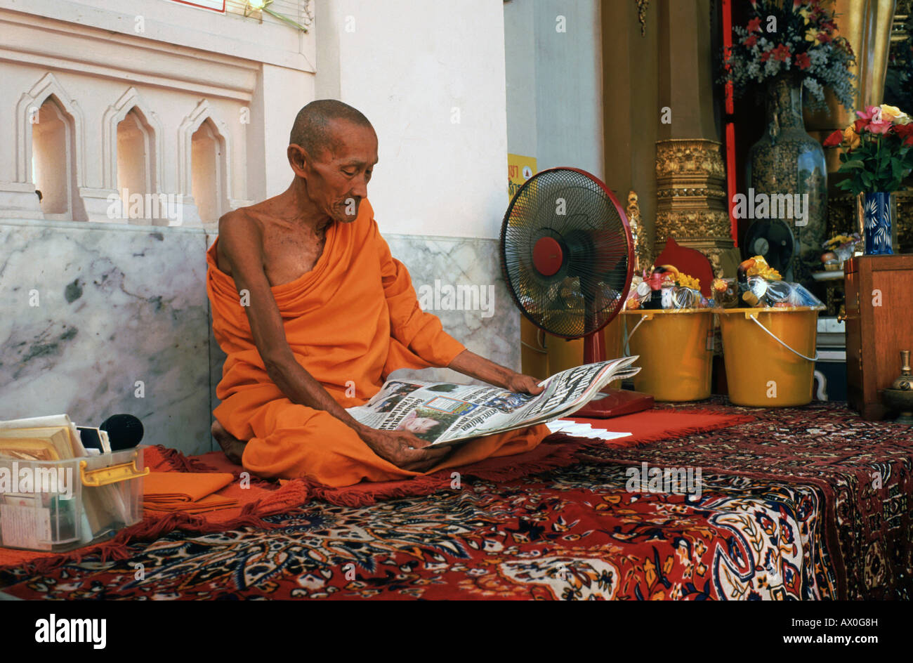 Vieux moine lisant le journal, Nakhon Pathom, Thaïlande, Asie Banque D'Images