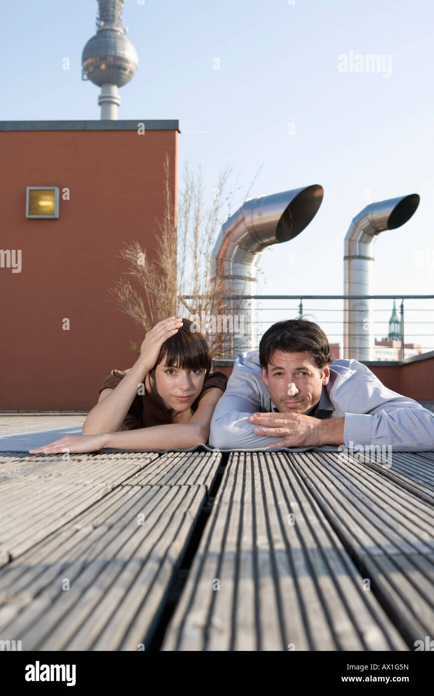Portrait d'un homme et d'une femme couché ensemble sur une terrasse sur le toit Banque D'Images