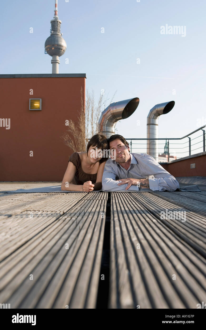 Portrait d'un homme et d'une femme couché ensemble sur une terrasse sur le toit Banque D'Images