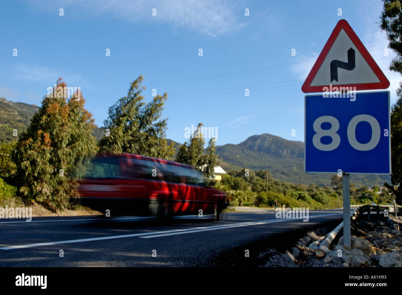 Voiture roulant sur une route avec des panneaux routiers de la limite de vitesse à 80 km/h et d'avertissement de courbes pour la route, Espagne Banque D'Images
