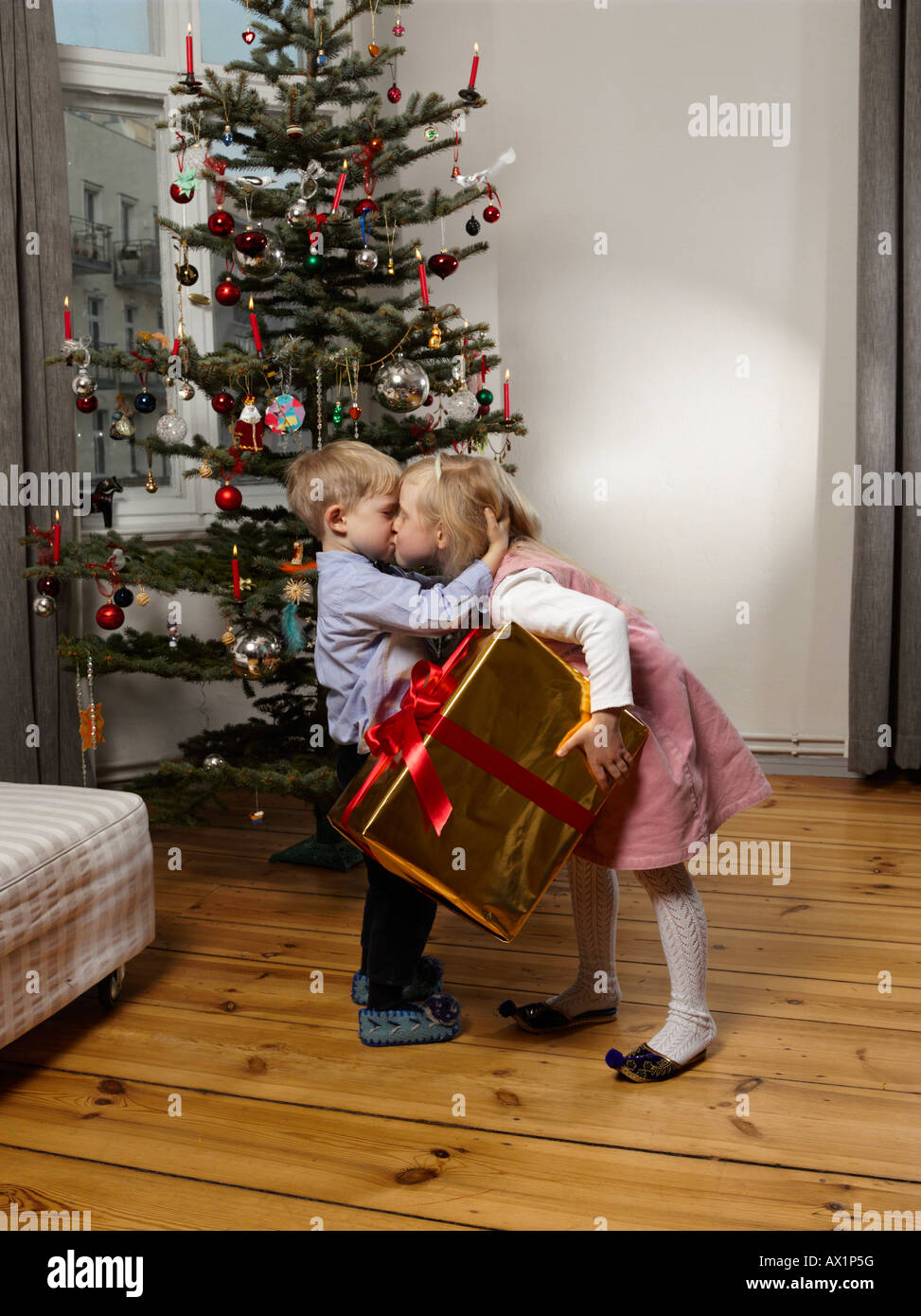 Frère et sœur s'embrasser devant un arbre de Noël Banque D'Images