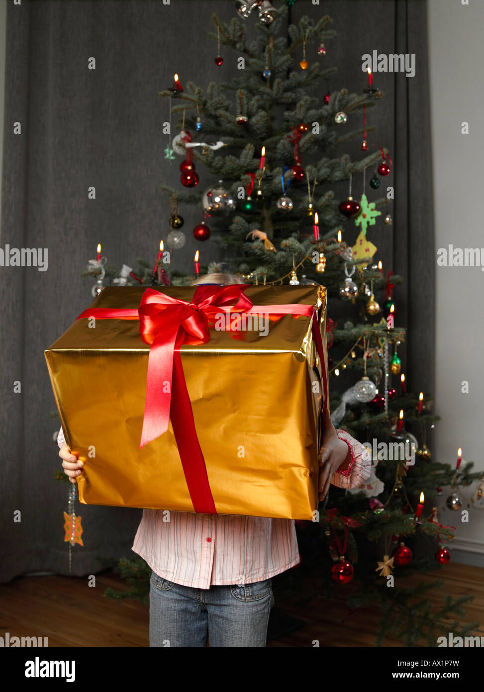 Un enfant tenant un gros cadeau de Noël Banque D'Images