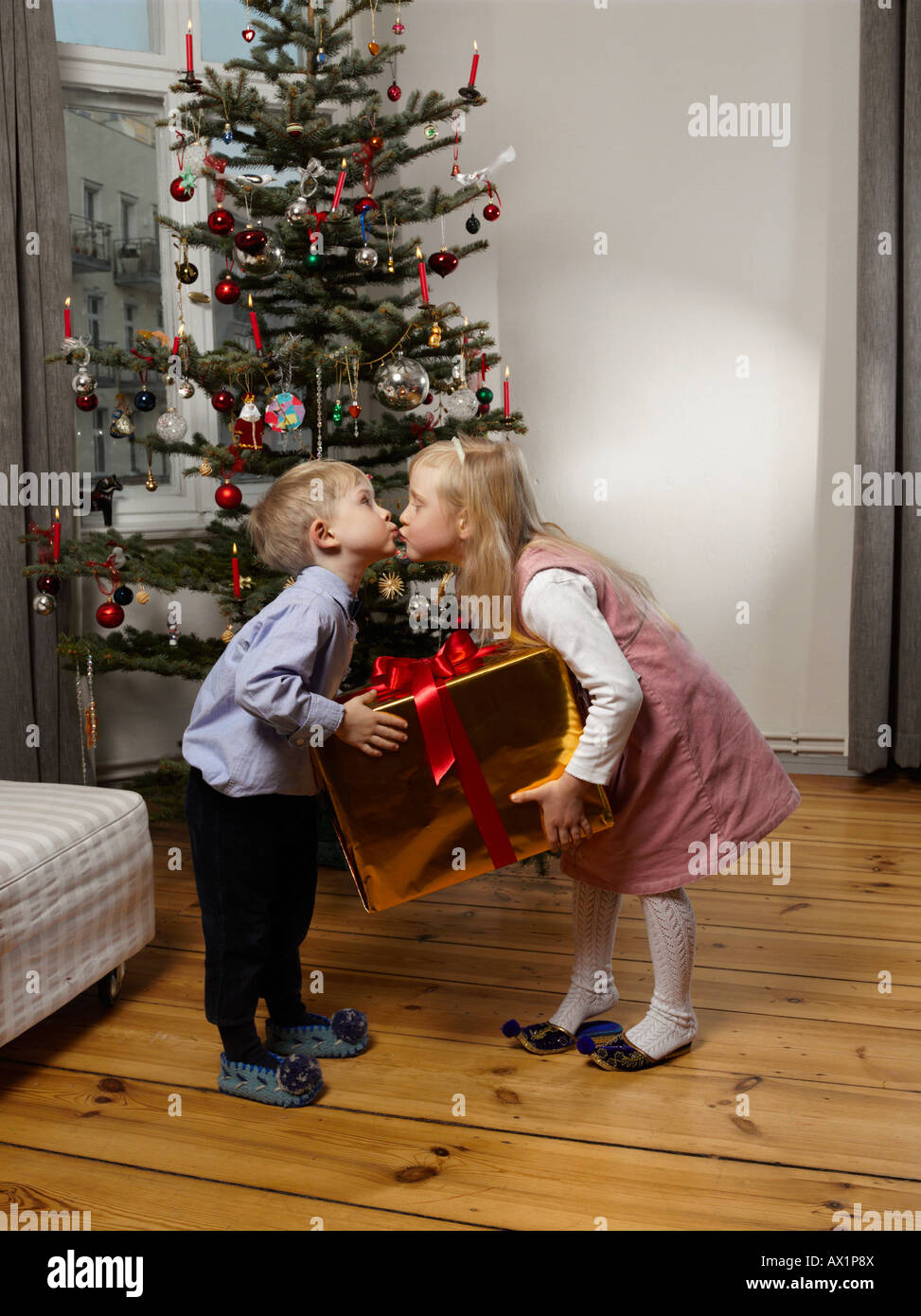 Deux enfants s'embrasser devant un arbre de Noël Banque D'Images