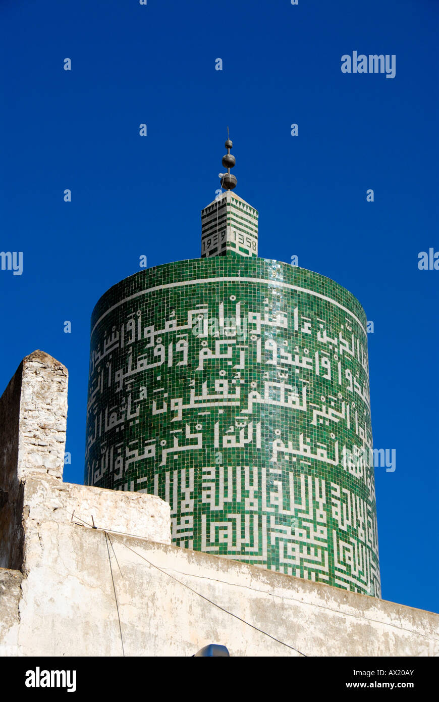 Minaret rond vert décoré d'écriture arabe lieu de pèlerinage islamique Maroc Moulay-Idriss Banque D'Images