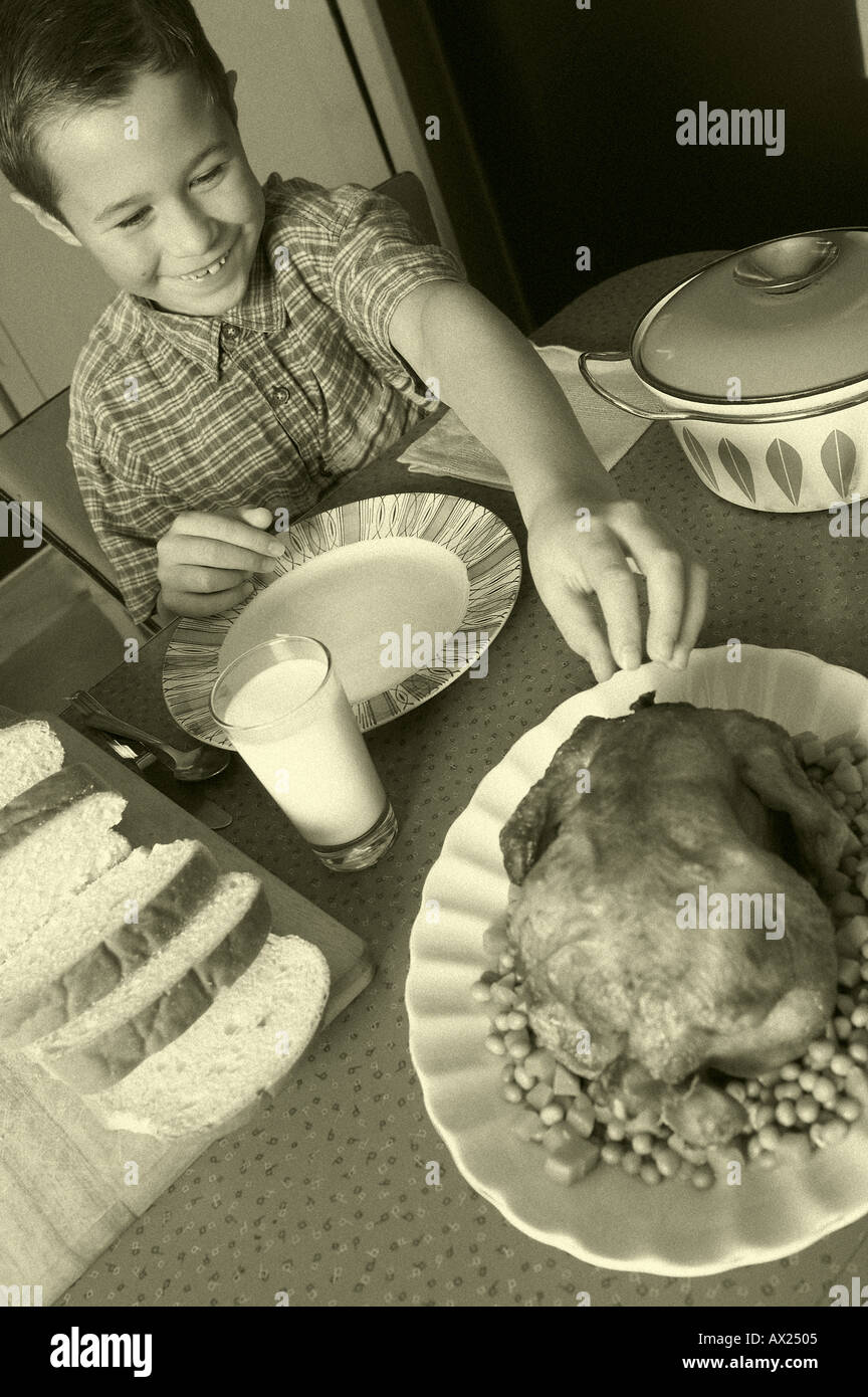 1950 garçon à la table du dîner avec l'uid de poulet 1426513 Banque D'Images