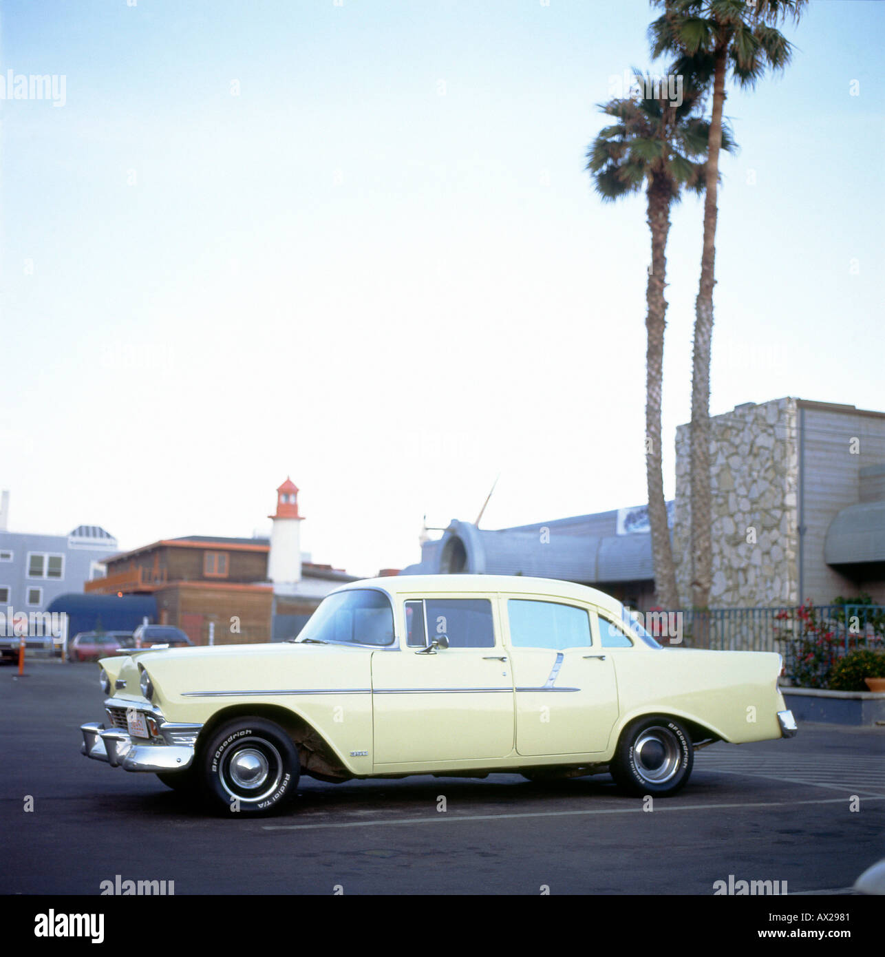 Années 1950 Années 1950 Chevrolet jaune pastel dans un parking avec des palmiers stationné à Malibu Los Angeles California USA KATHY DEWITT Banque D'Images