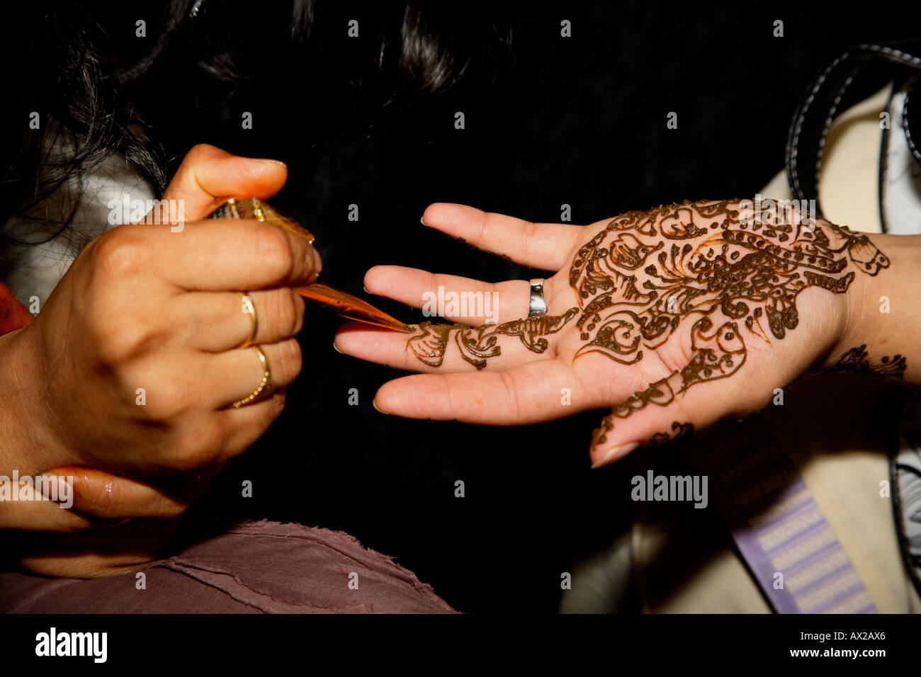 Jeune femme peinture tatouage au henné (mehndi) sur place au Salon de l'Asie, Londres, Olympia 2006 Banque D'Images