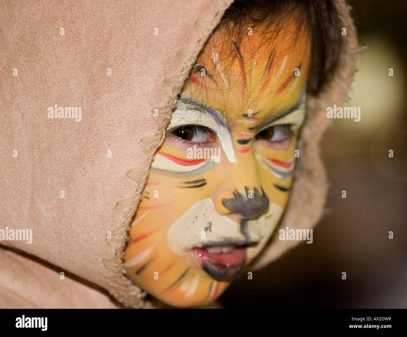 Parution modèle portrait of young girl composé avec facepaint pour ressembler à un tigre retour sur son épaule Banque D'Images