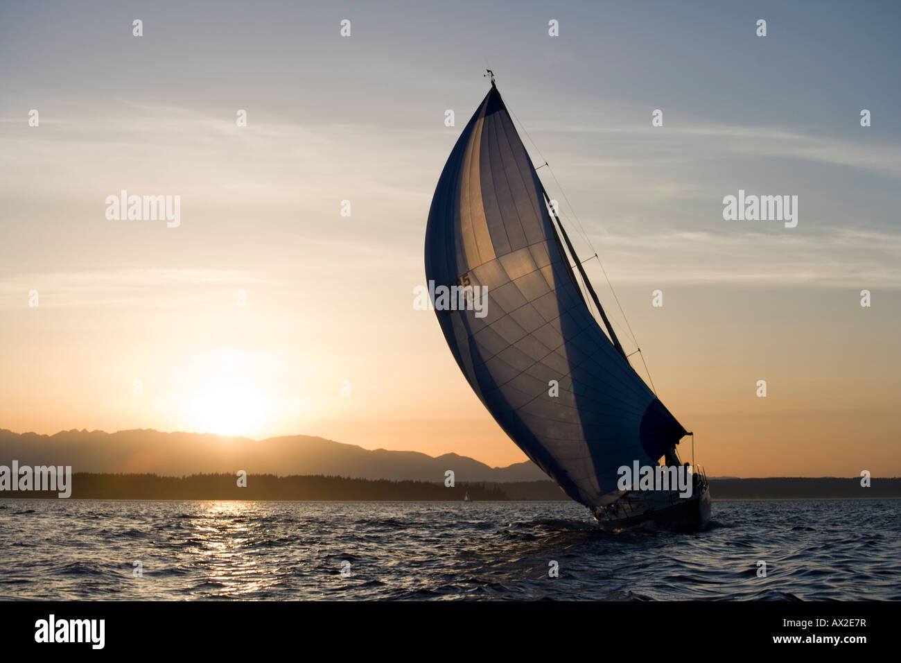 USA Washington Seattle Setting sun lights yacht de voile à Elliot Bay sur soirée de printemps Banque D'Images