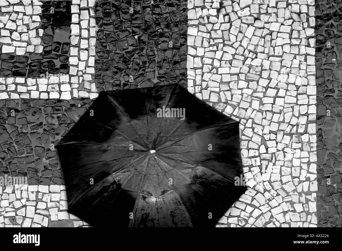 Coup de frais généraux personne exerçant le parapluie ouvert mosaïque typique trottoir à Rio de Janeiro Brasil Brésil Banque D'Images