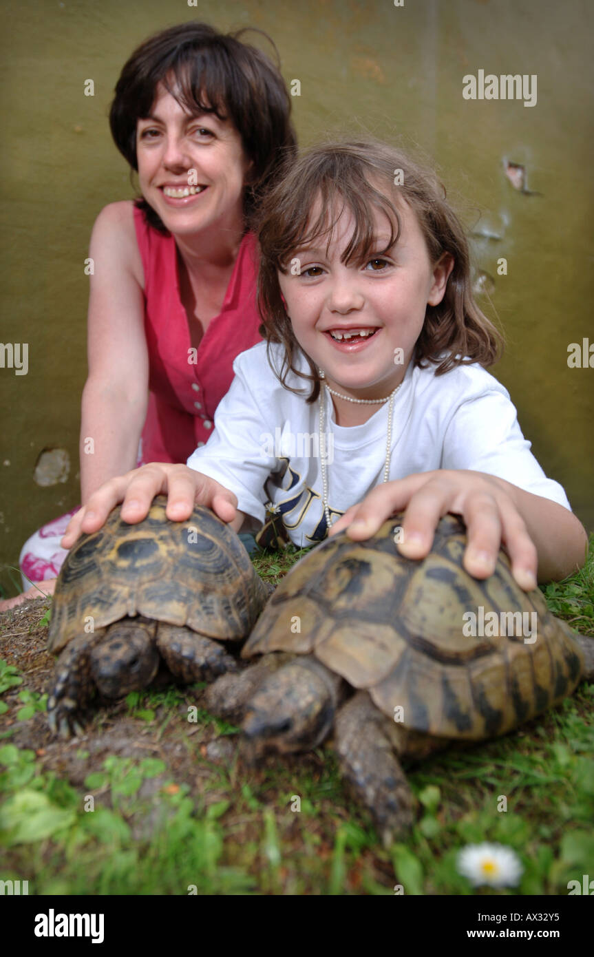 Un enfant avec sa mère avec deux tortues d'ANIMAUX DOMESTIQUES EN COIN À Longleat Safari Park près de Salisbury Wiltshire Banque D'Images